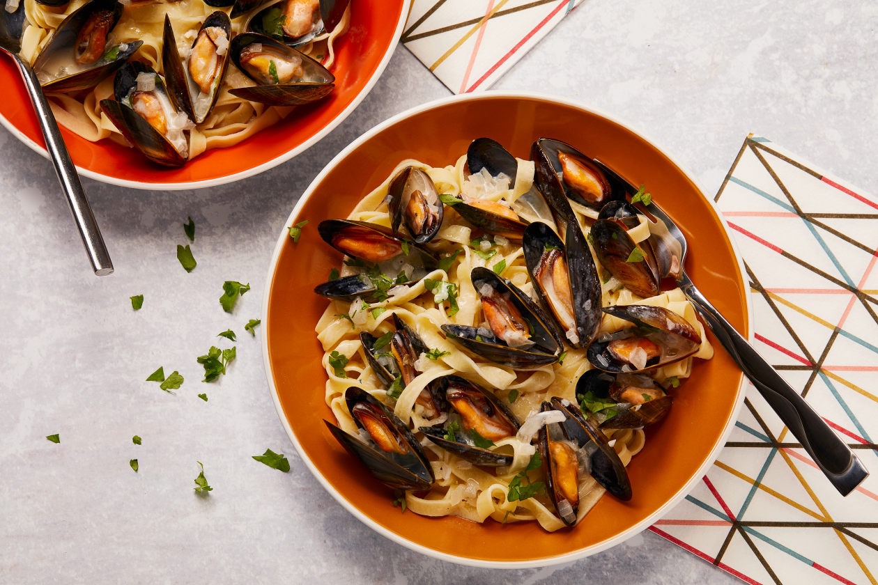 A photograph of Mussels with creamy white wine sauce and tagliatelle